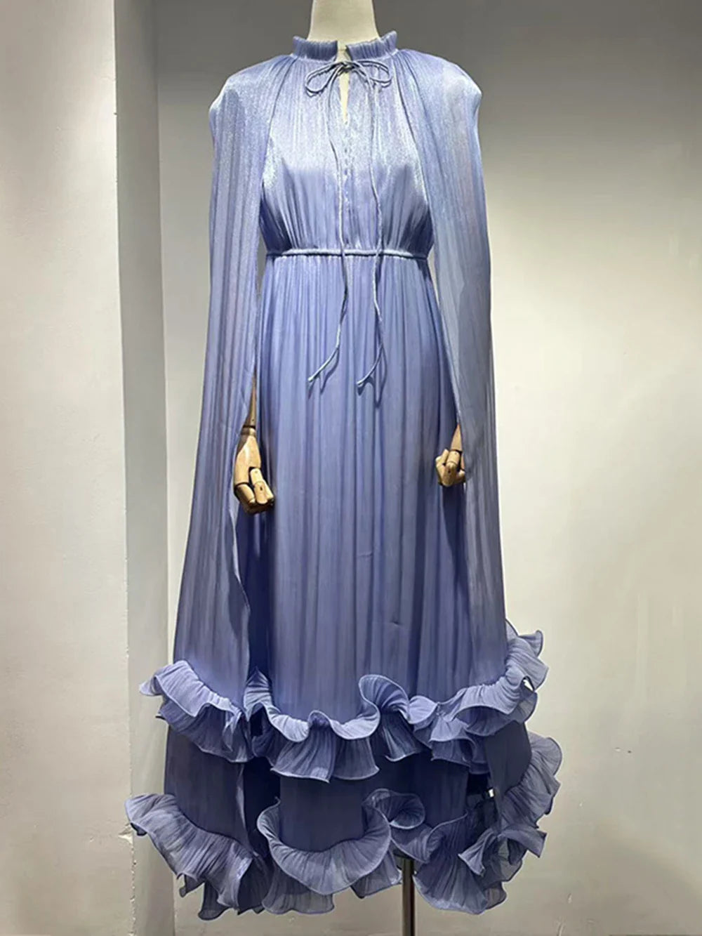 Blue dress with ruffled hem on a mannequin against a plain background