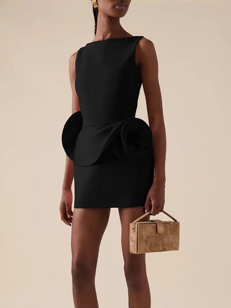 Woman wearing a black dress with a bow detail on a beige background