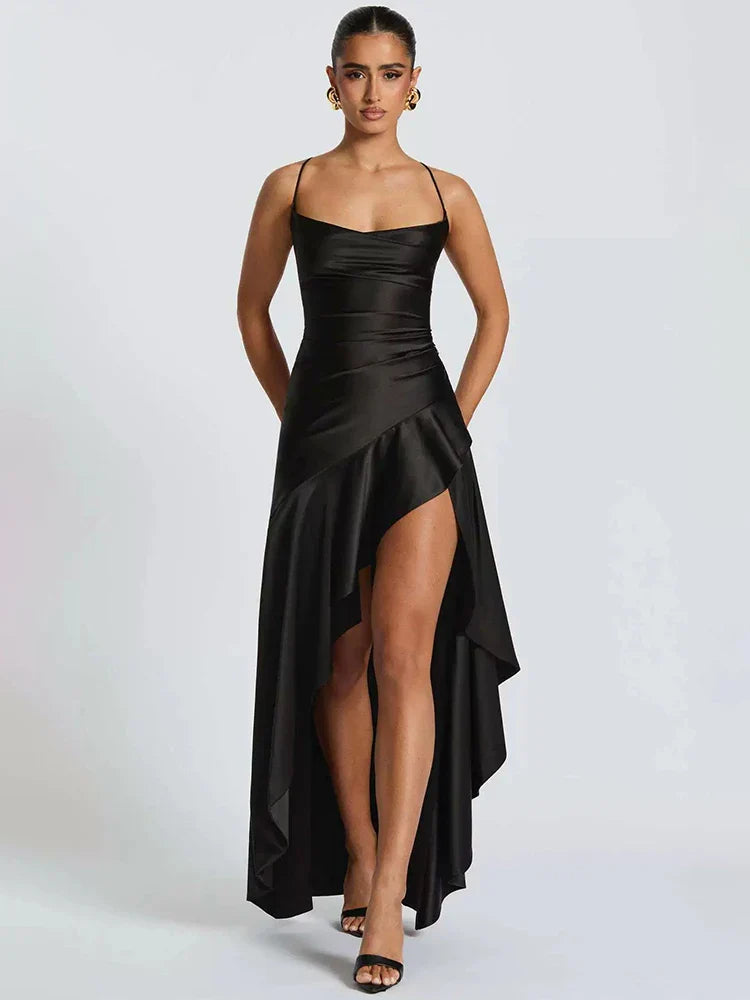 Woman wearing a black satin dress with a high slit on a white background