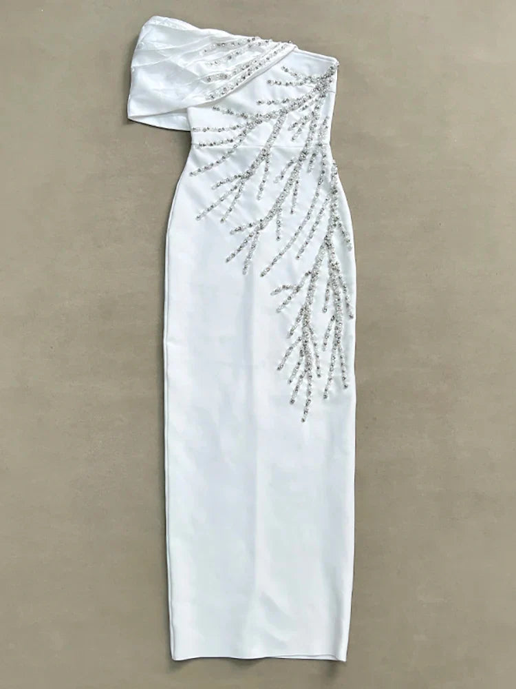 White one-shoulder dress with beading on a beige background