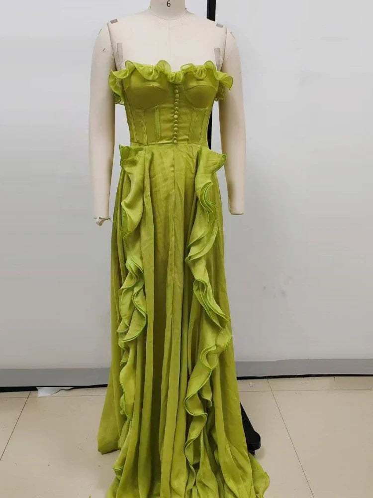 Mannequin wearing a lime green evening gown with ruffled details against a plain background