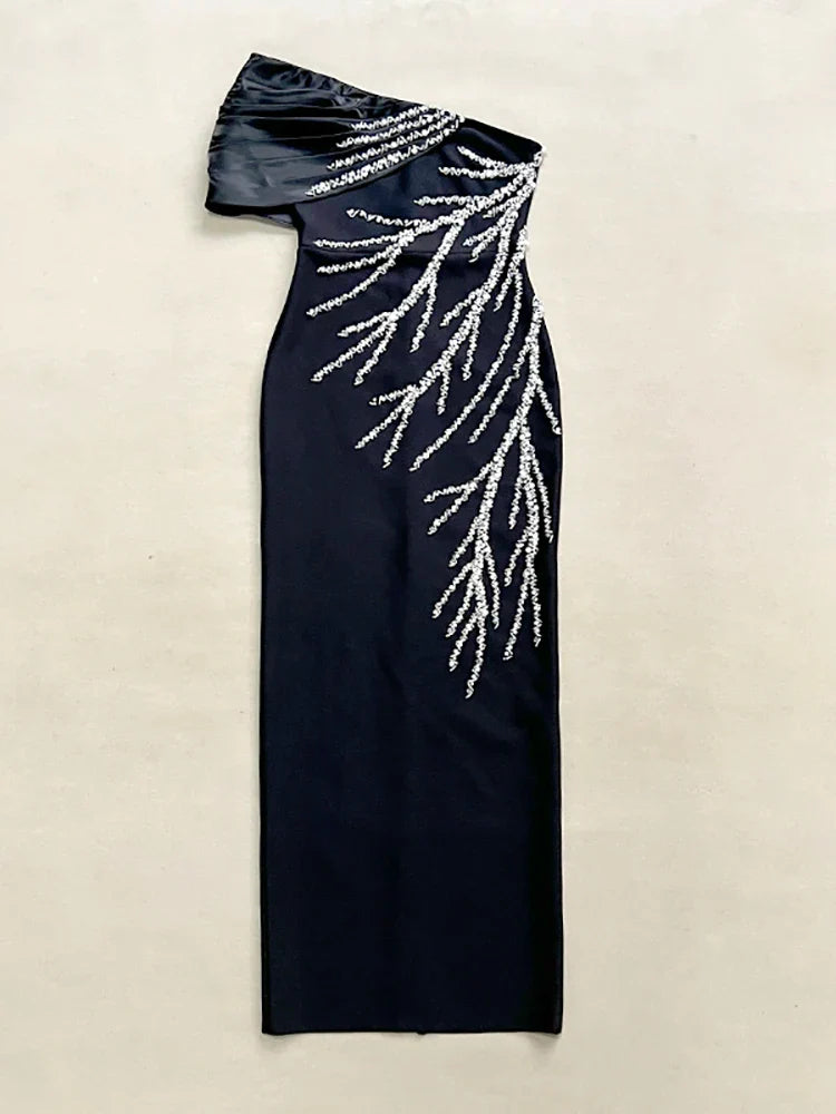 Black evening gown with silver bead detailing on a beige background