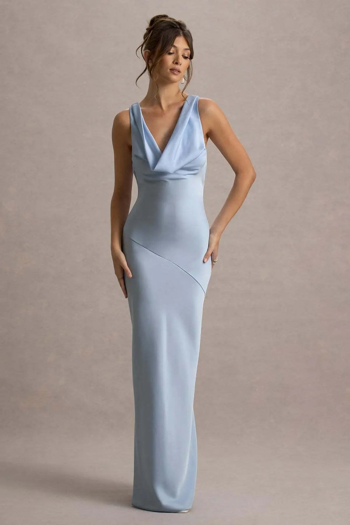 Woman wearing a light blue evening gown against a neutral background