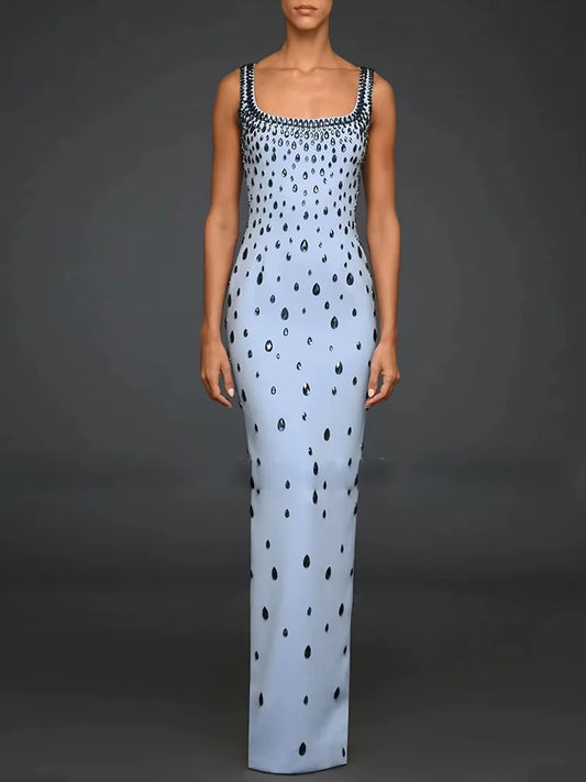 Woman wearing a light blue dress with black polka dots on a dark gray background