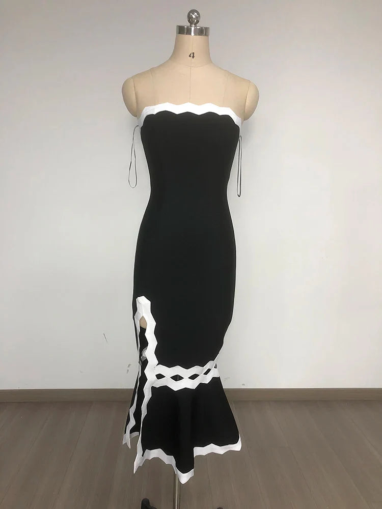 Black dress with white lace details on a mannequin against a plain background