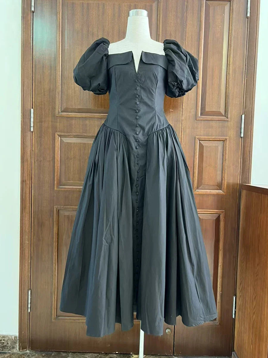 Dark gray dress on a mannequin against a wooden door background