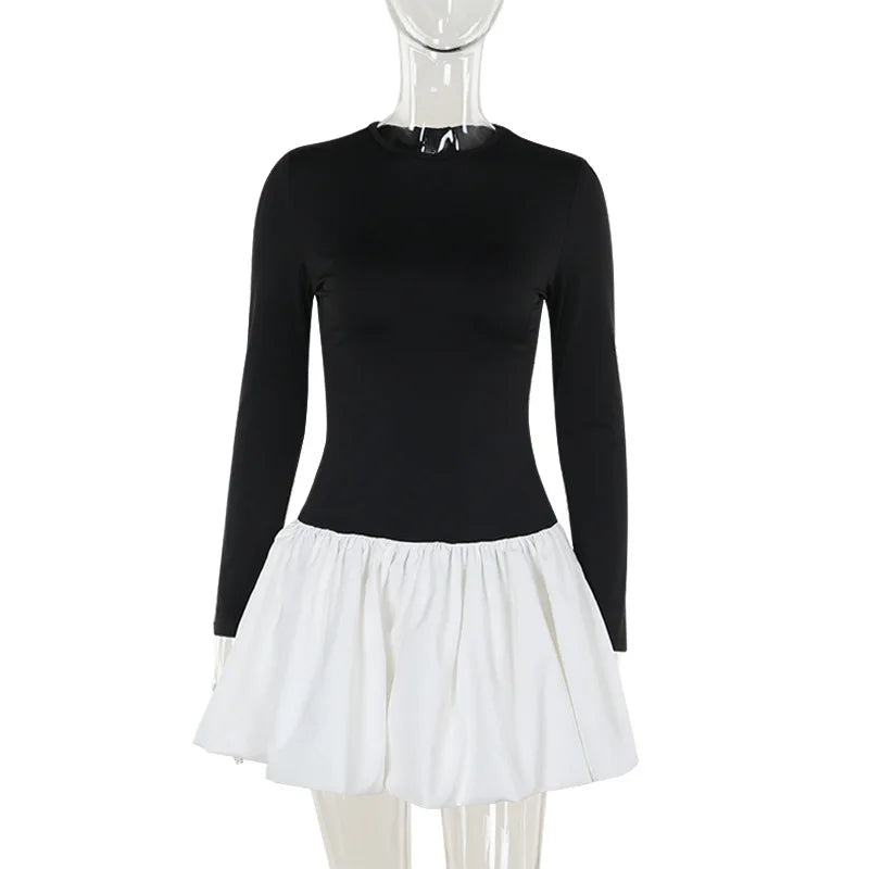 Mannequin wearing a black long-sleeve top and white skirt