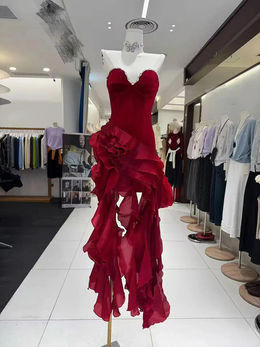 Red dress on a mannequin in a store setting with other clothing in the background