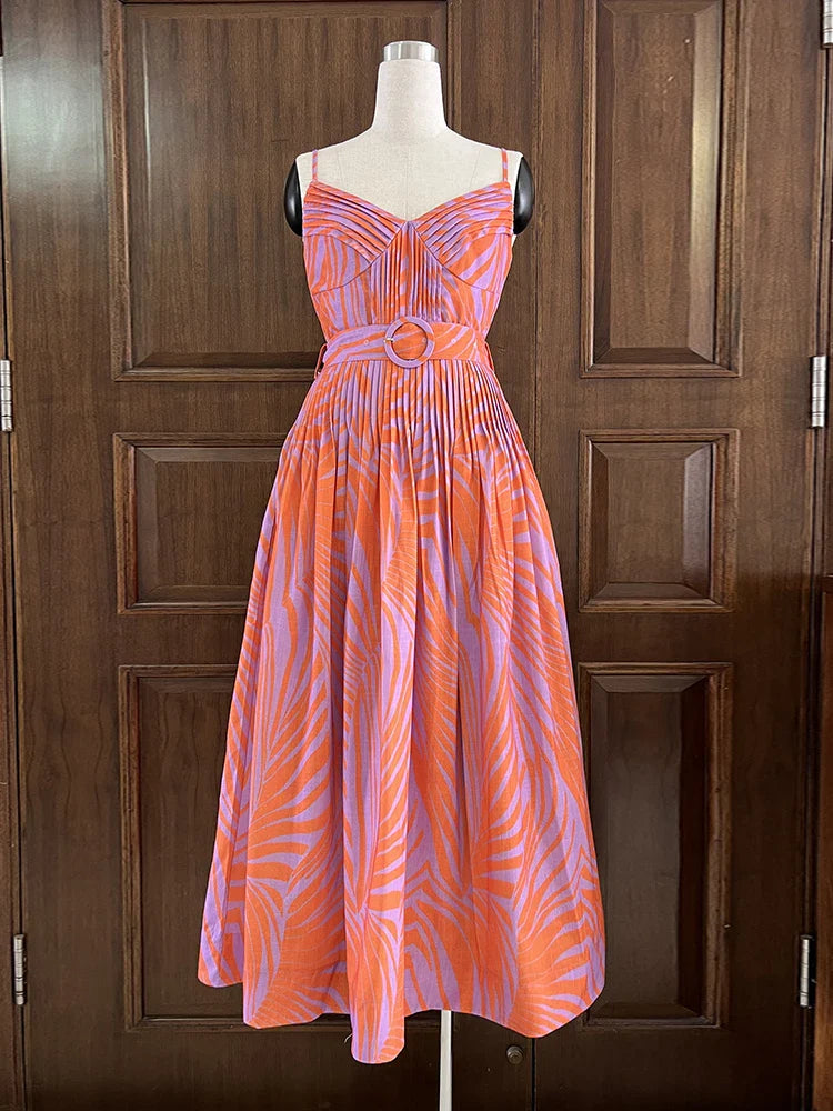 Orange and purple patterned dress on a mannequin against a wooden door background