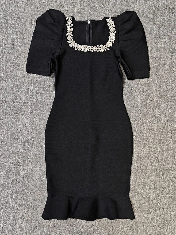 Black dress with floral embellishments on a gray background
