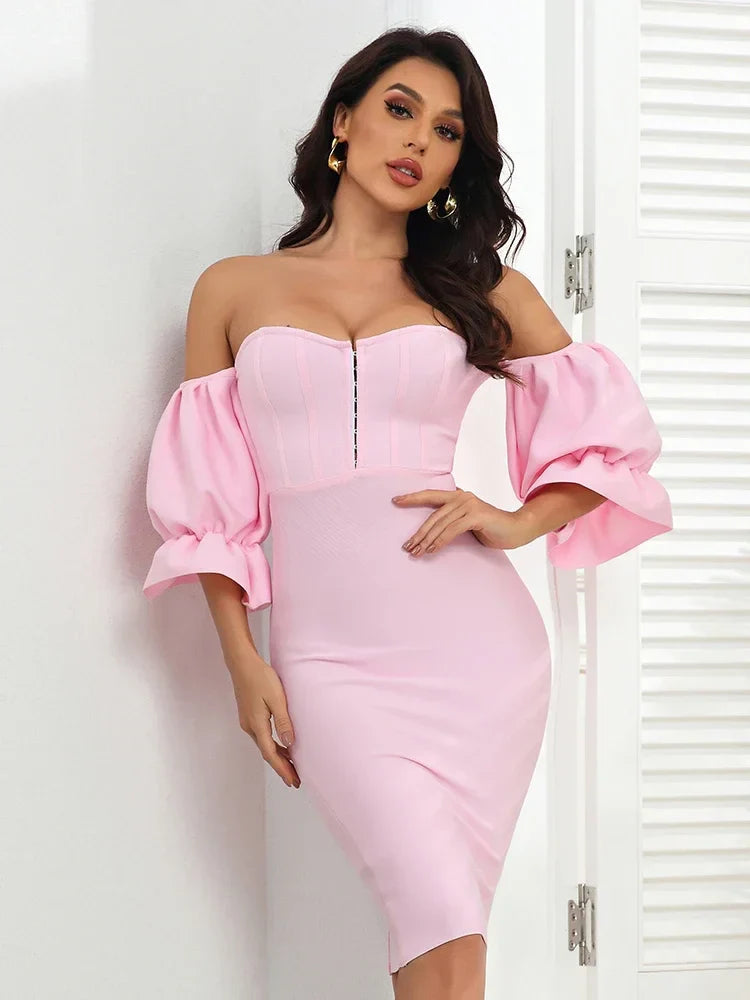 Woman wearing a pink off-shoulder dress with puffed sleeves against a white background