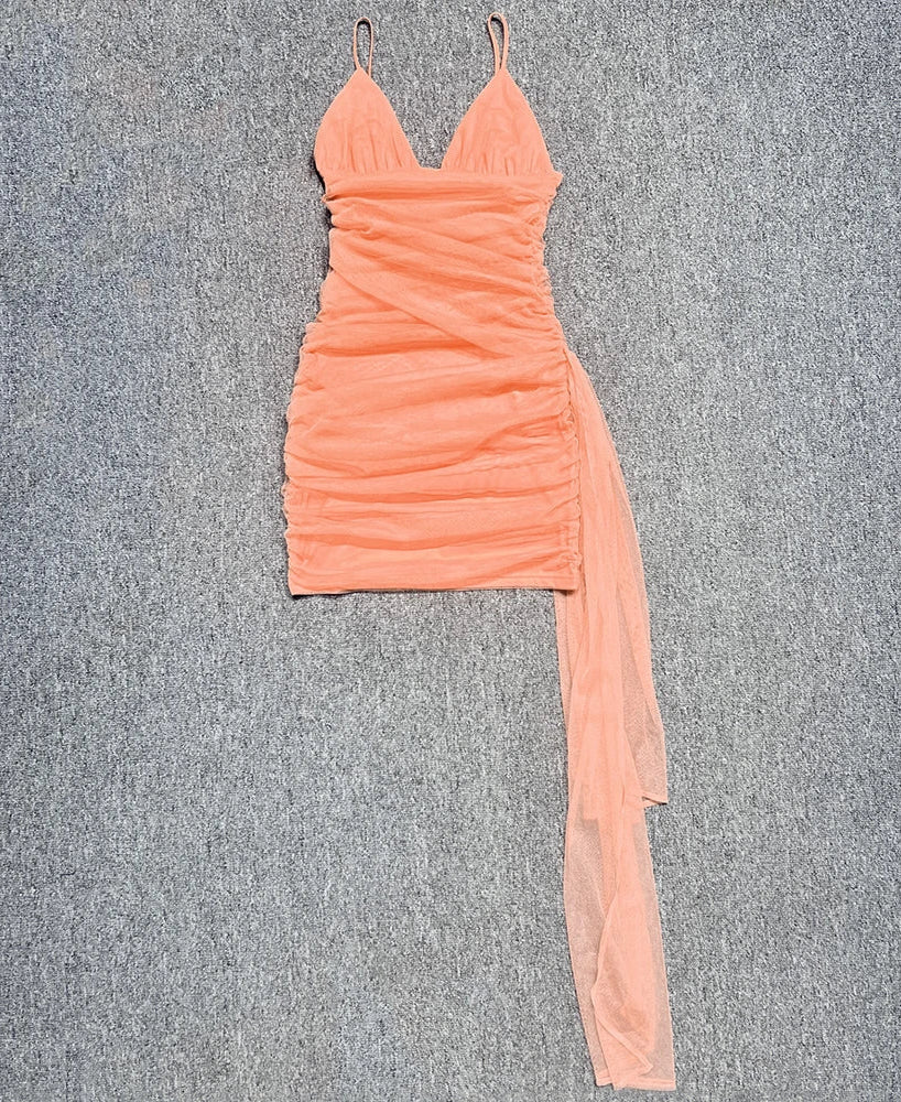 Peach-colored dress with a sheer side panel on a gray background
