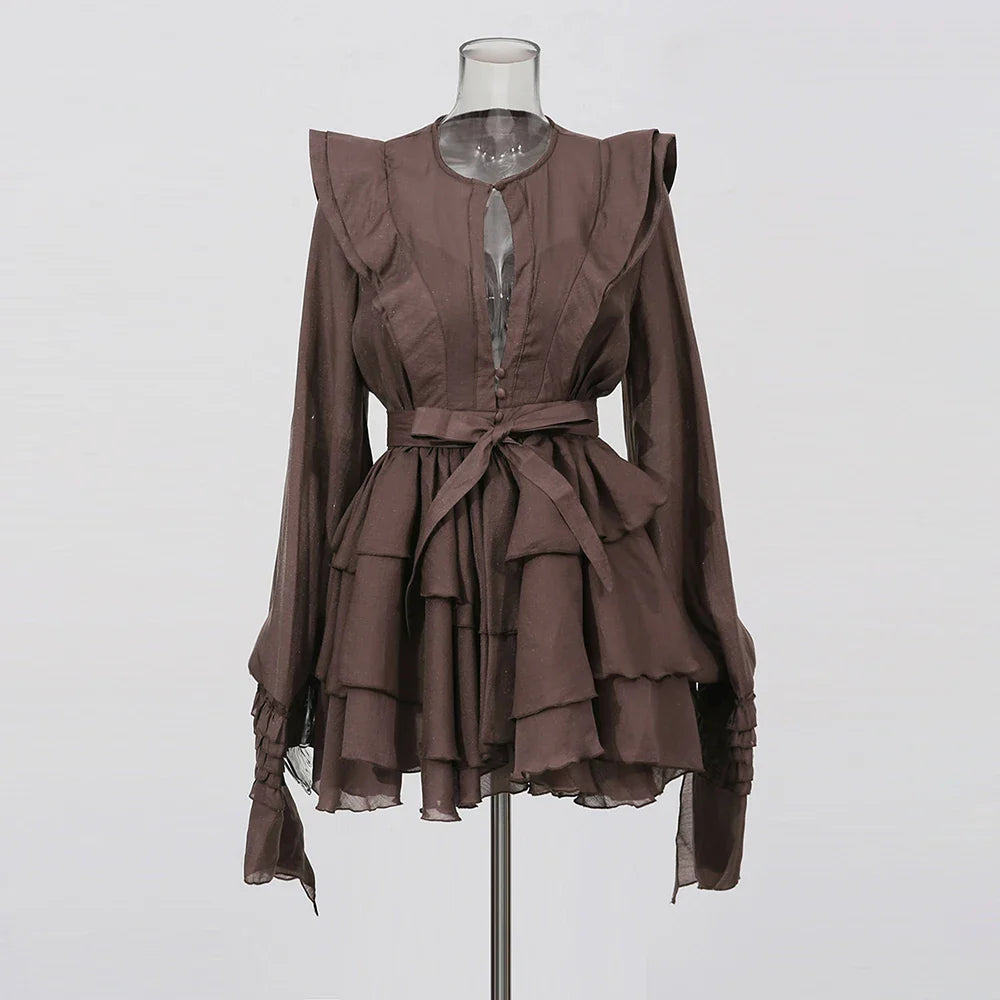 Brown ruffled dress on a mannequin against a white background