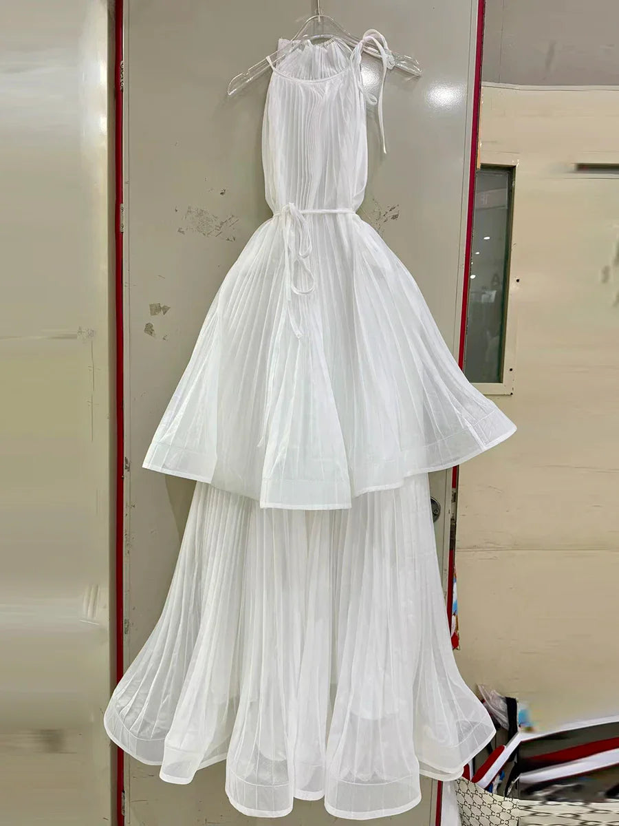 White dress hanging on a rack against a neutral background
