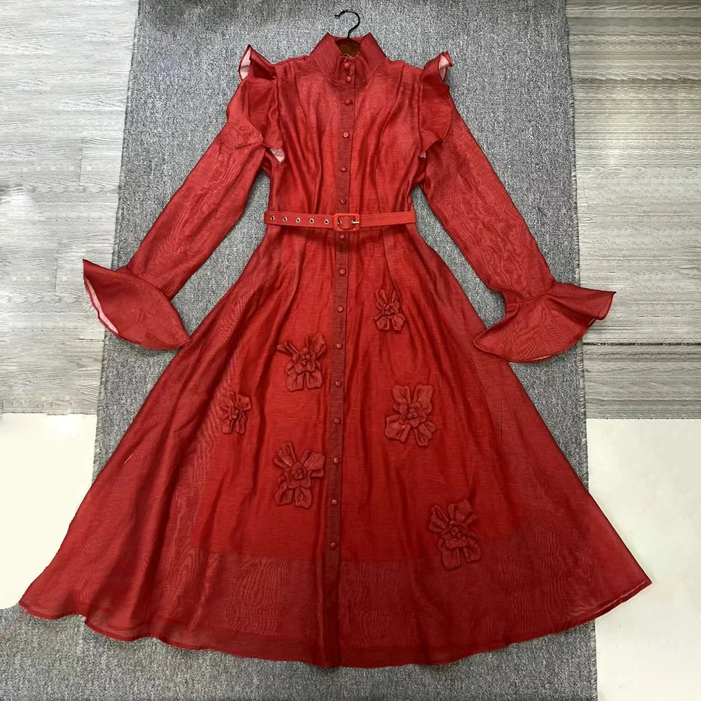 Red dress with floral embellishments on a gray surface