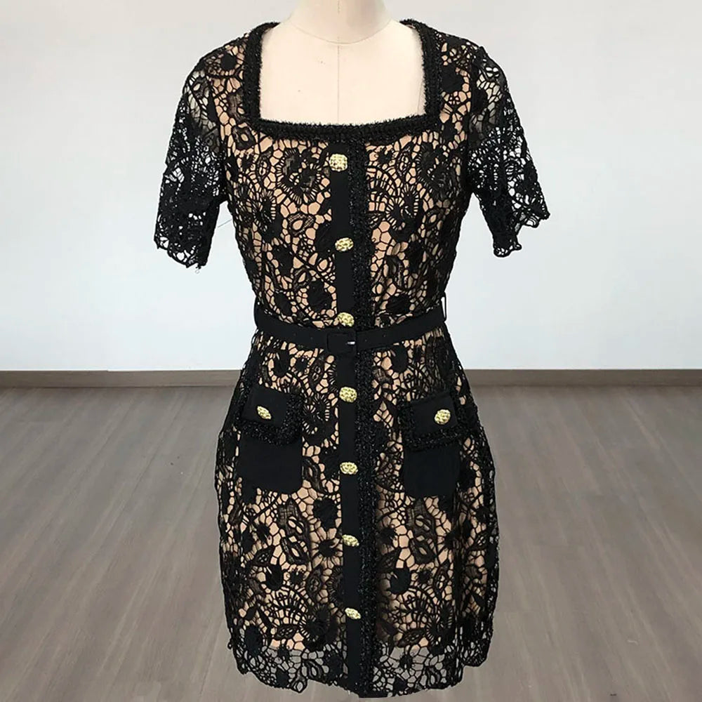 Black lace dress on a mannequin against a white wall.