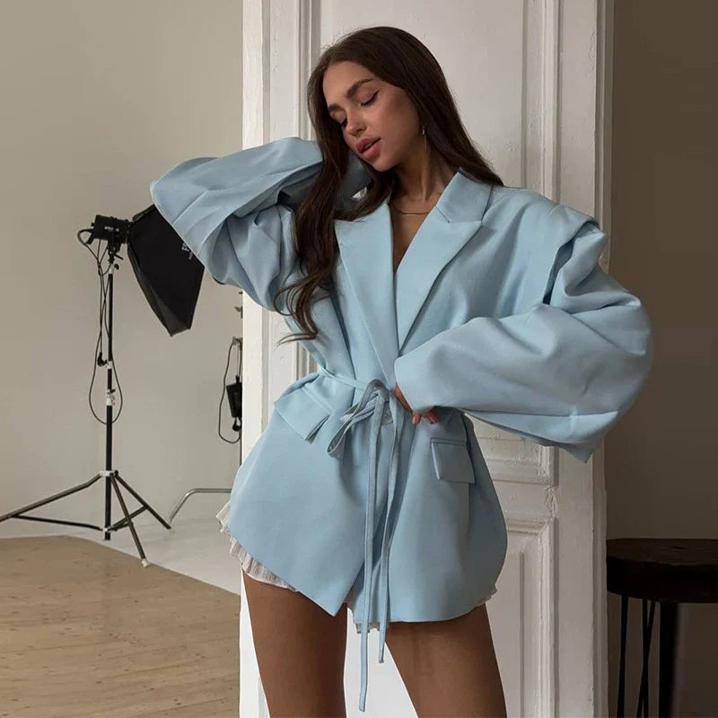 Woman wearing a light blue robe in a studio setting