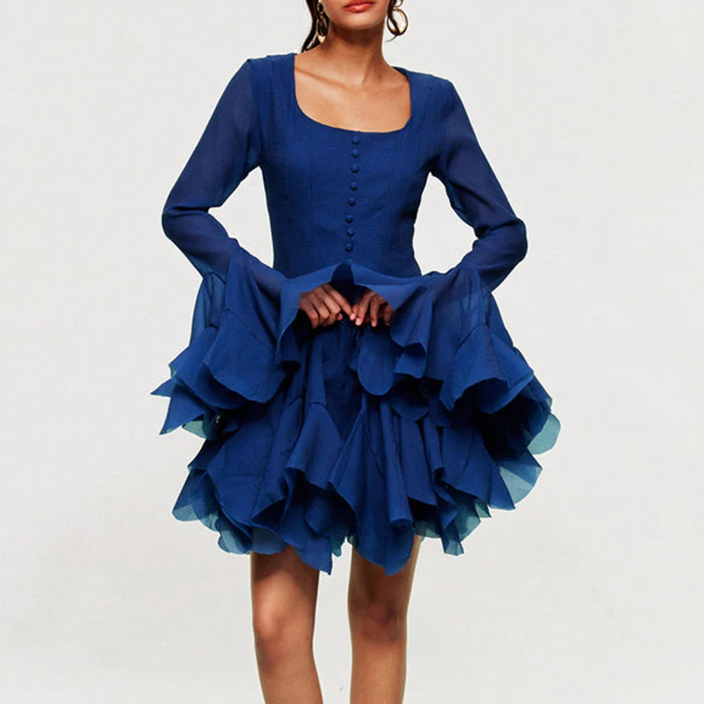 Woman wearing royal blue ruffle mini dress on white background