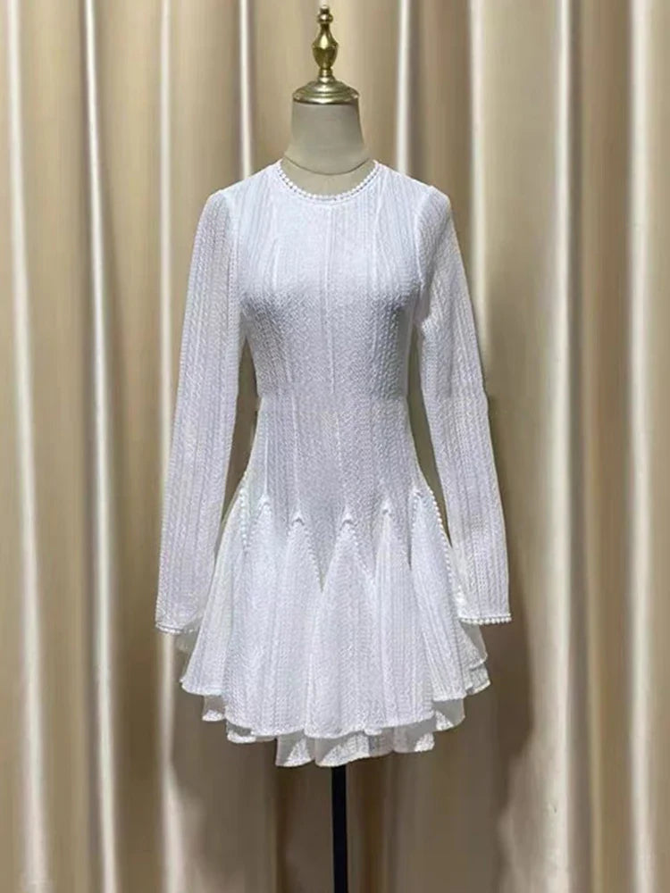 White dress on a mannequin against a beige curtain background