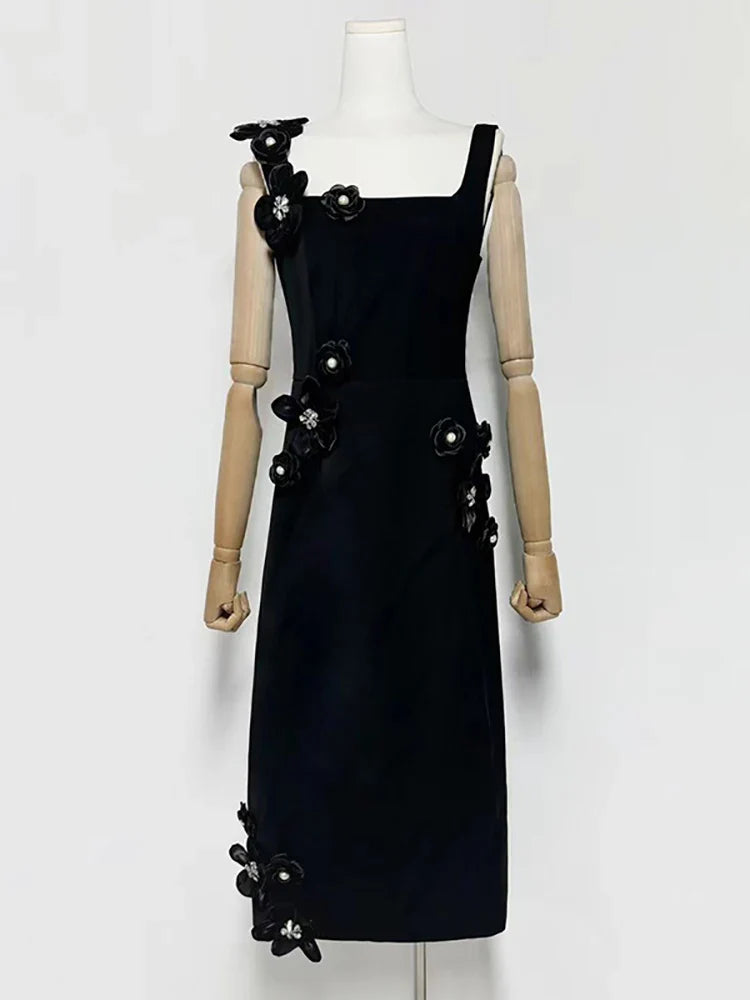 Black dress with floral embellishments on a mannequin against a white background