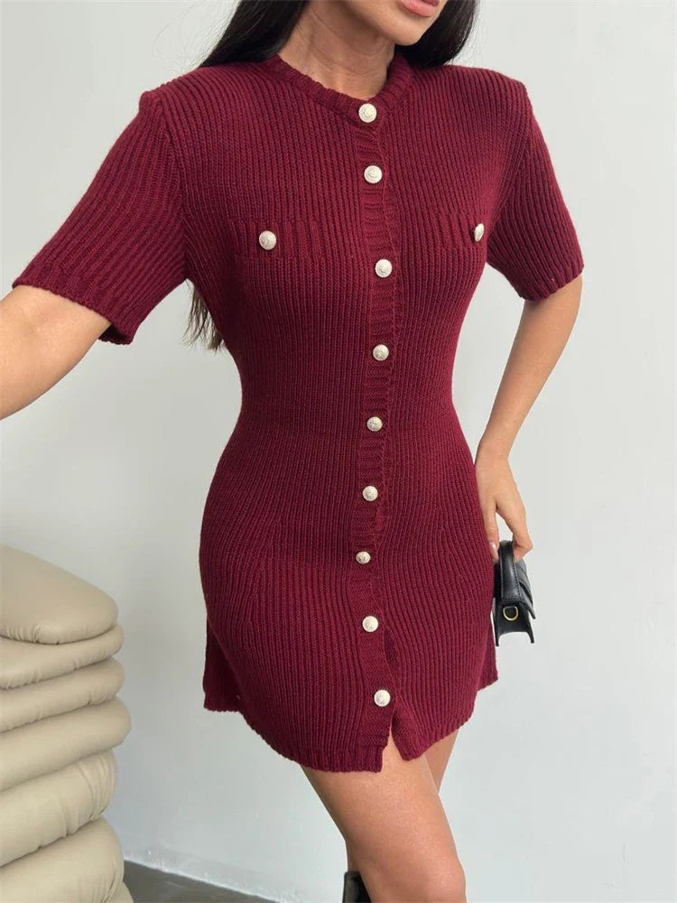 Maroon ribbed dress with white buttons worn by a person, against a plain background