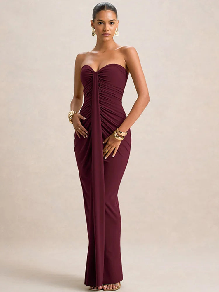 Woman wearing a burgundy strapless gown on a beige background