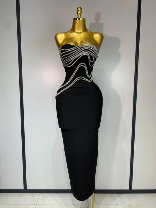 Black evening gown with silver embellishments on a mannequin against a neutral background