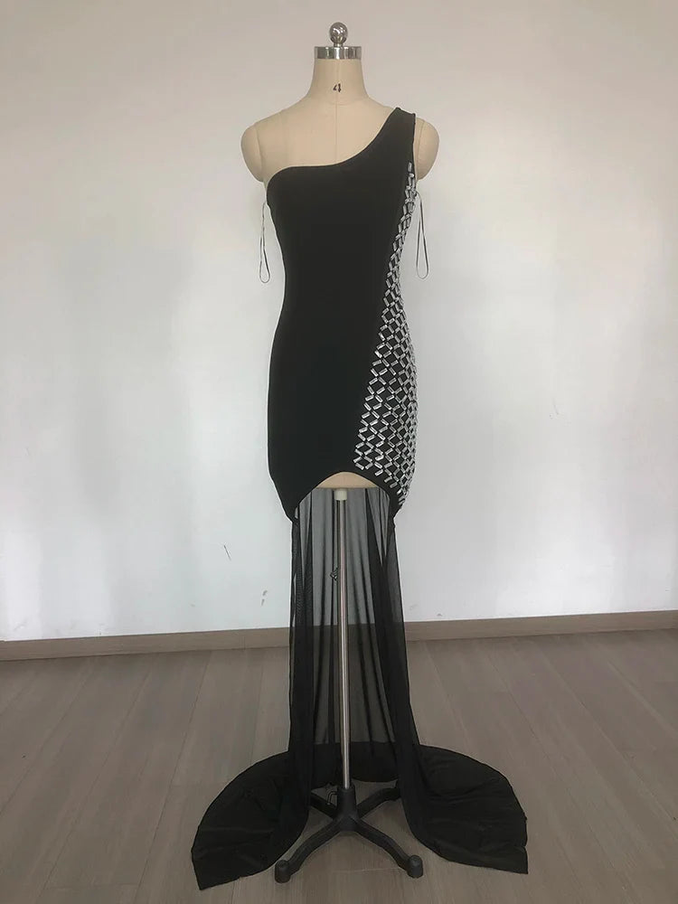 Black one-shoulder dress with sheer overlay on a mannequin against a white background