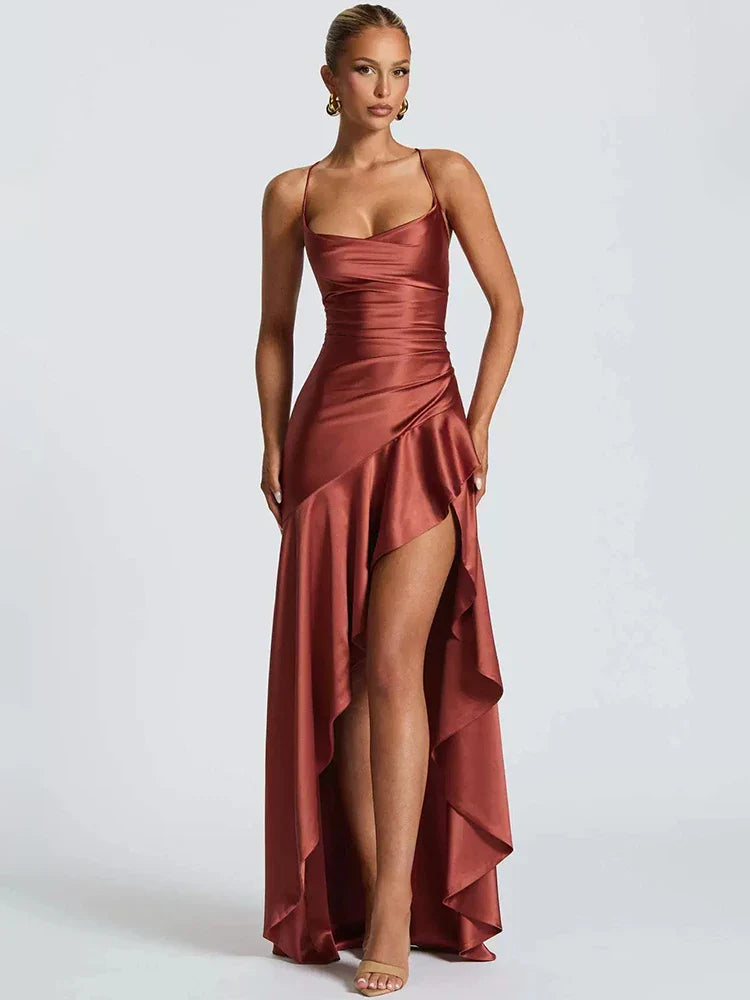 Woman wearing a rust-colored evening gown with a slit on a white background