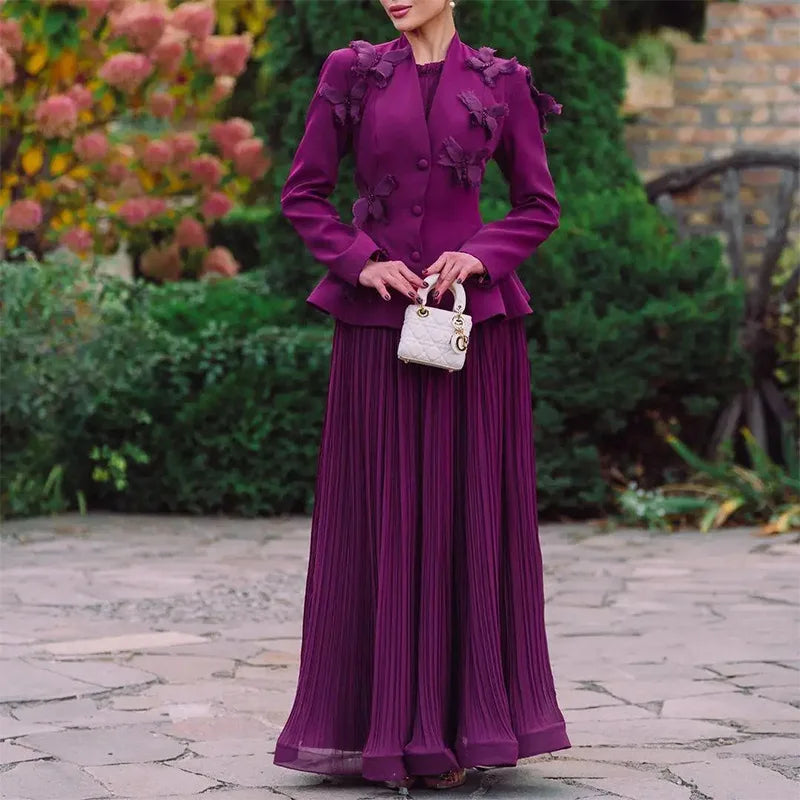 Woman in a purple outfit standing outdoors with greenery in the background