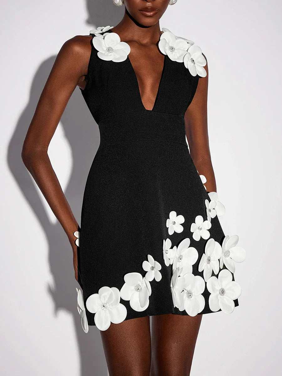 Black dress with white floral embellishments on a plain background