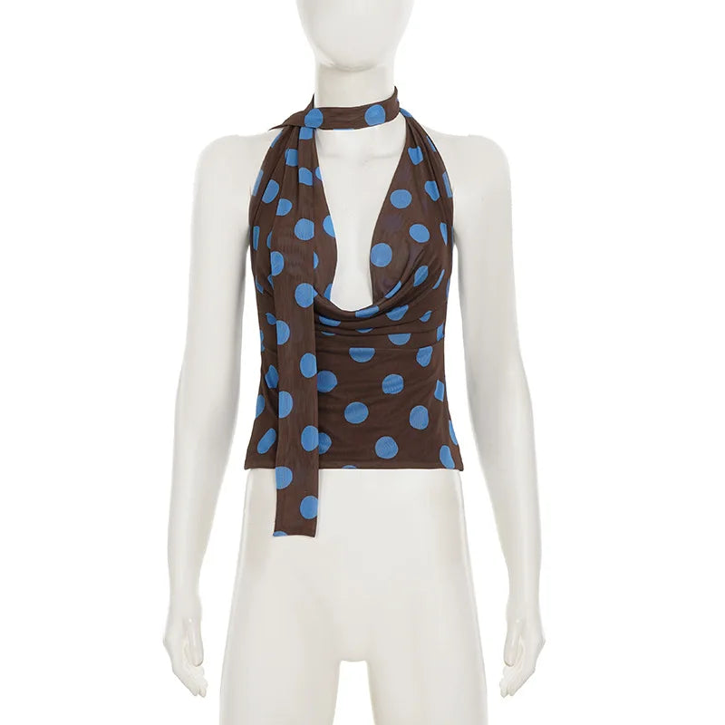 Mannequin wearing a brown top with blue polka dots on a white background