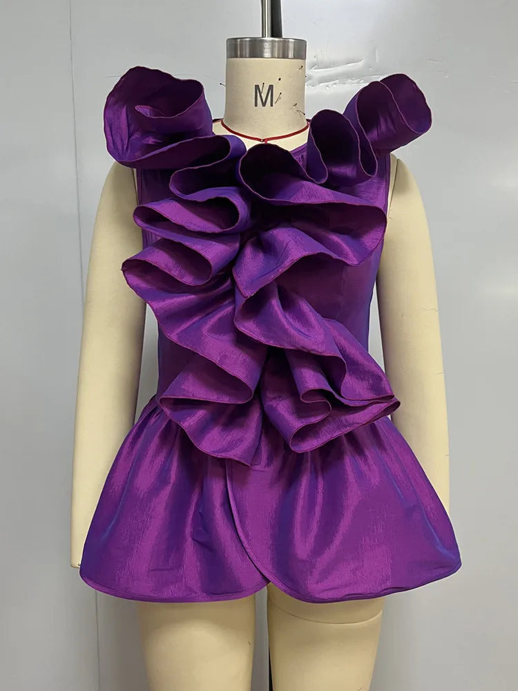 Purple ruffled dress on a mannequin against a plain background