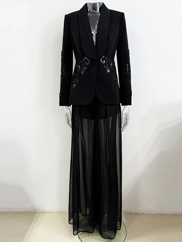 Black formal outfit with a jacket and sheer skirt on a mannequin against a white background
