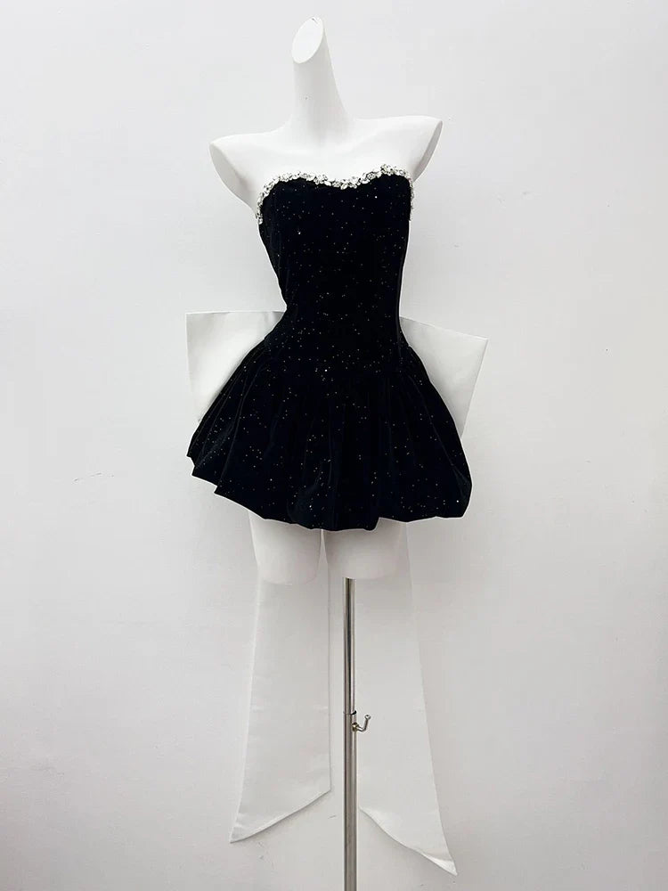 Black strapless dress on a mannequin against a white background