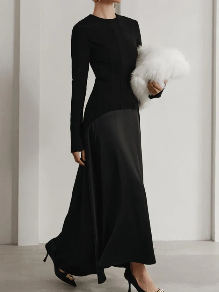 Woman wearing a black long-sleeve dress holding a white fur ball 