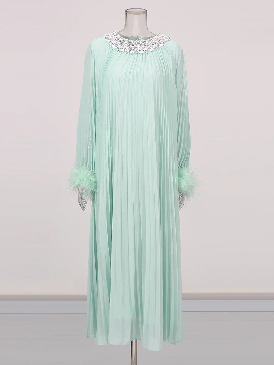 Mint green dress with floral embellishments on a mannequin against a light gray background