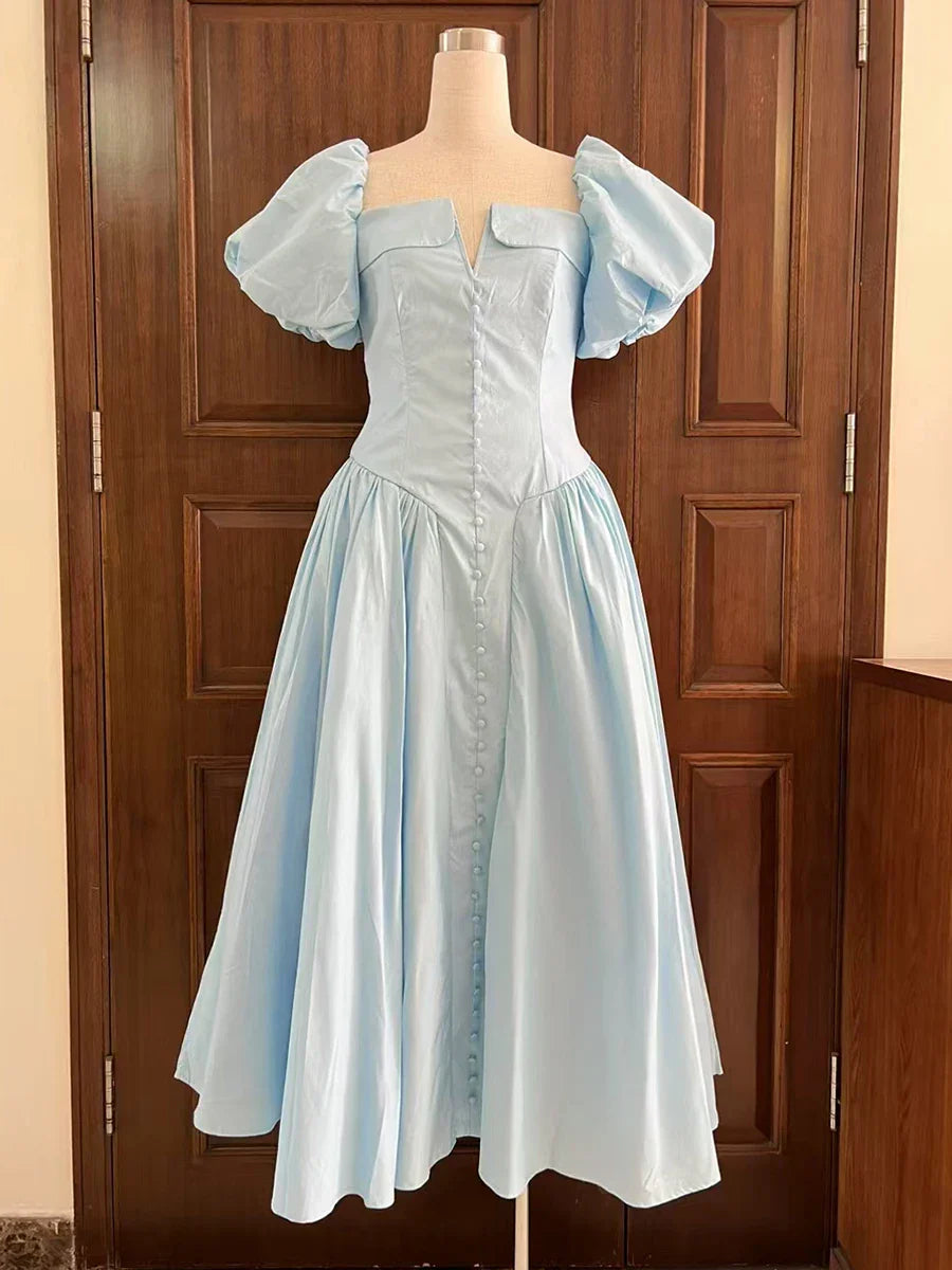Light blue dress on a mannequin against a wooden door background