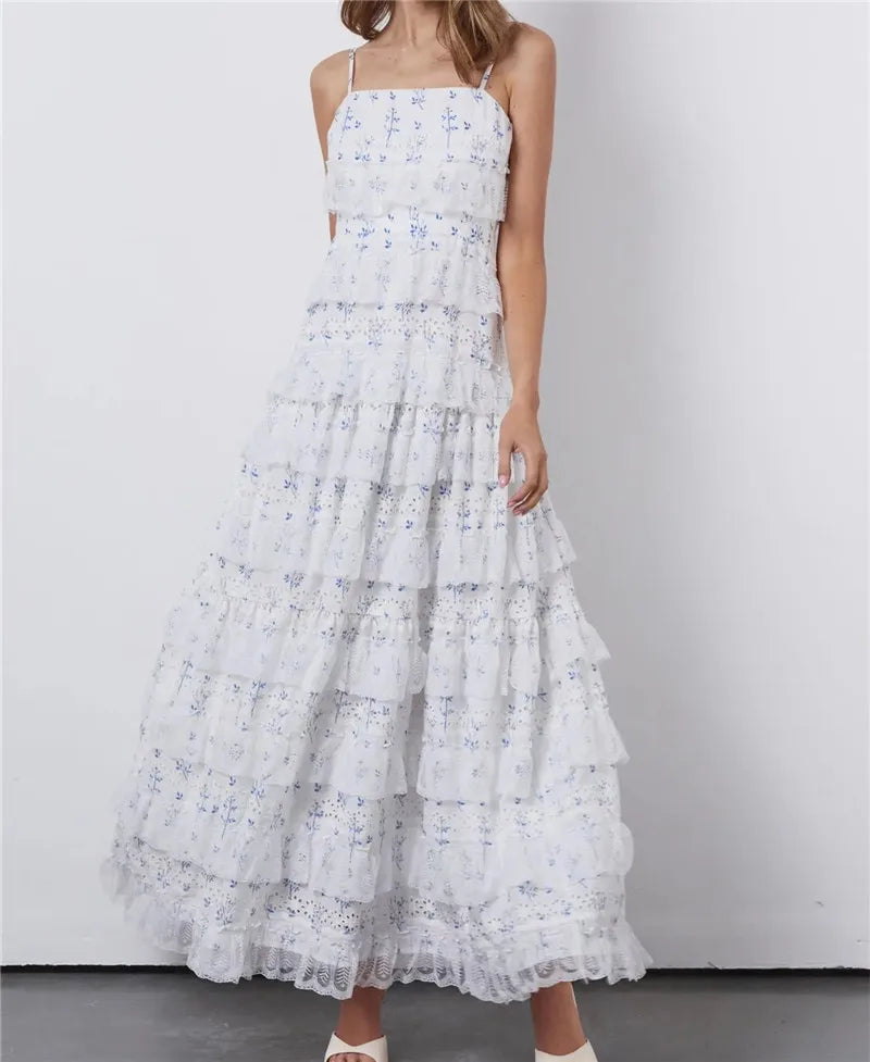 White floral dress with ruffled layers on a plain background