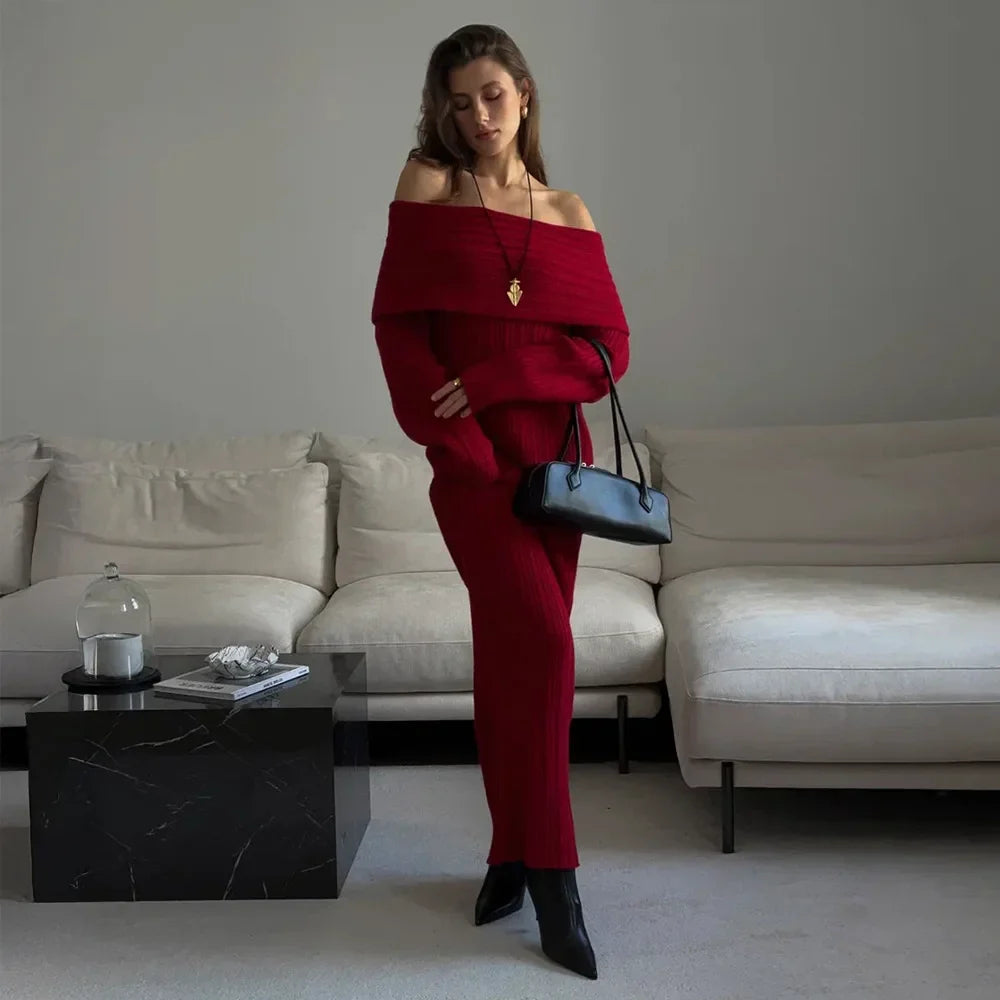 Woman in a red outfit holding a black handbag in a modern living room.
