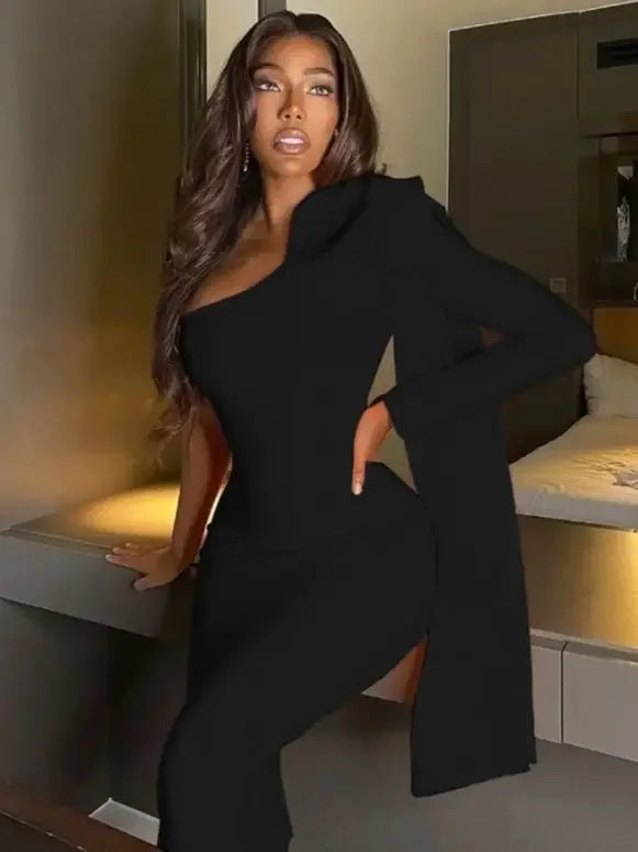 Woman in a black outfit sitting on a ledge indoors