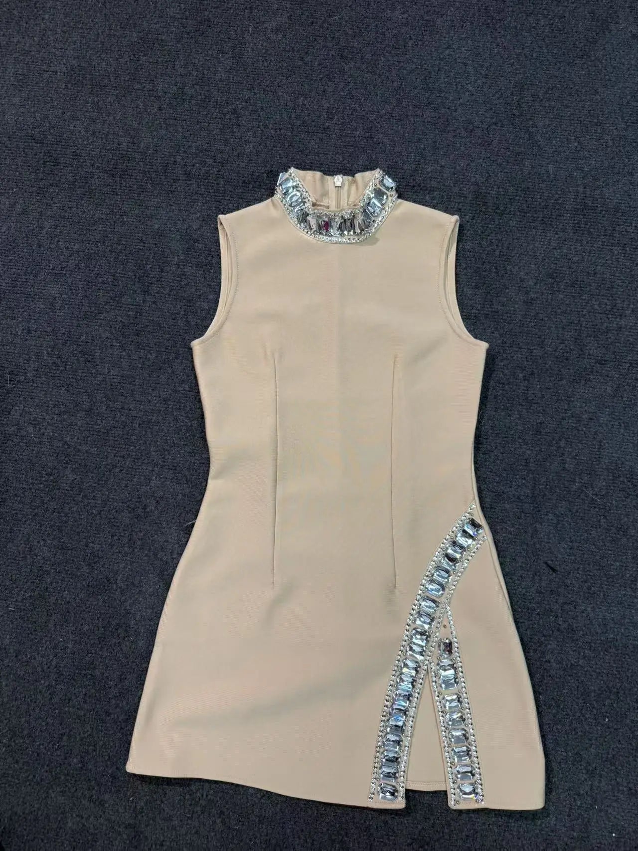 Beige dress with blue embellishments on a dark background