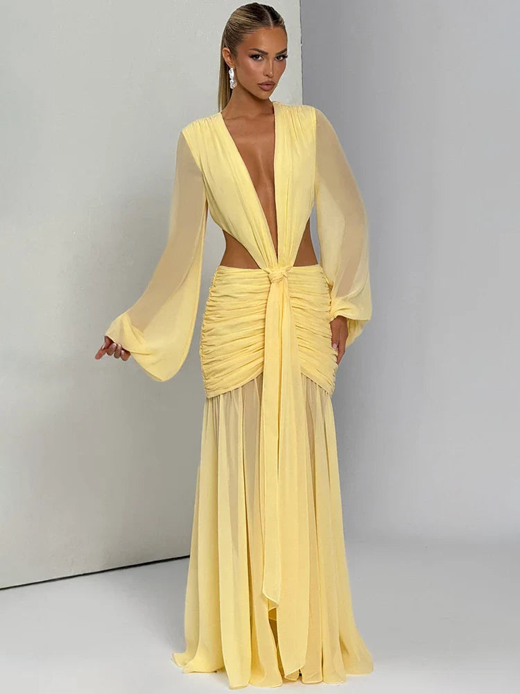 Woman wearing a yellow evening gown against a plain background