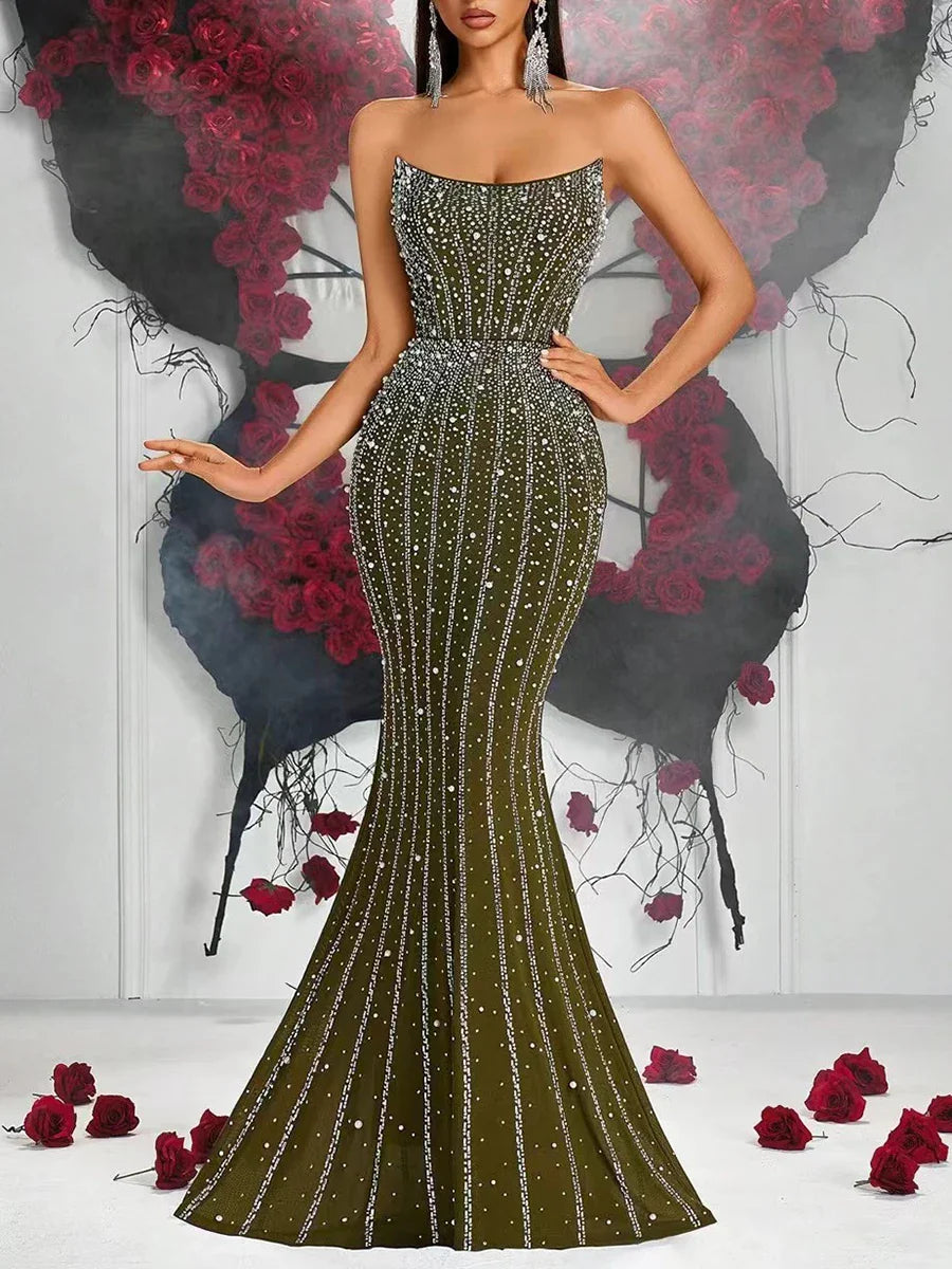 Woman wearing a sparkling green evening gown with a floral and black background