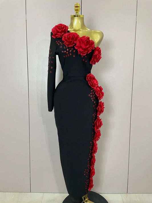 Black dress with red floral embellishments on a mannequin against a white background
