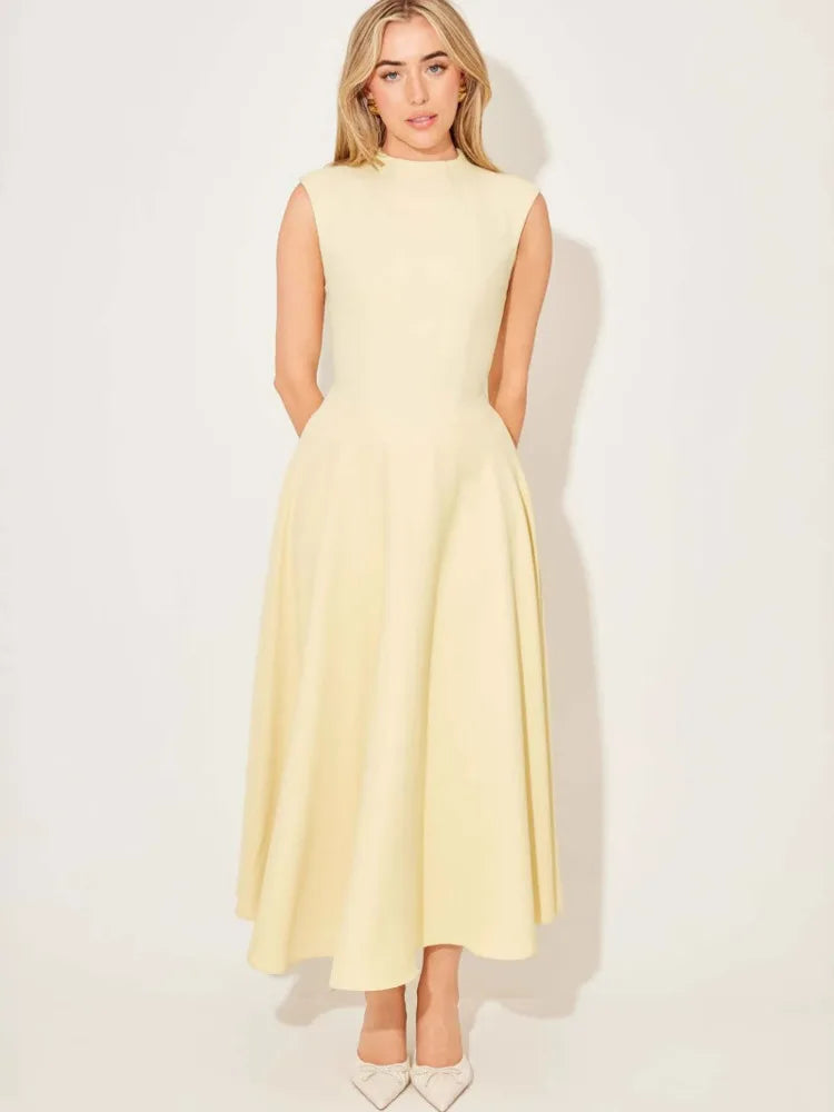 Woman wearing a light yellow dress against a white background