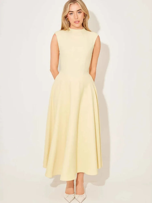 Woman wearing a light yellow dress against a white background