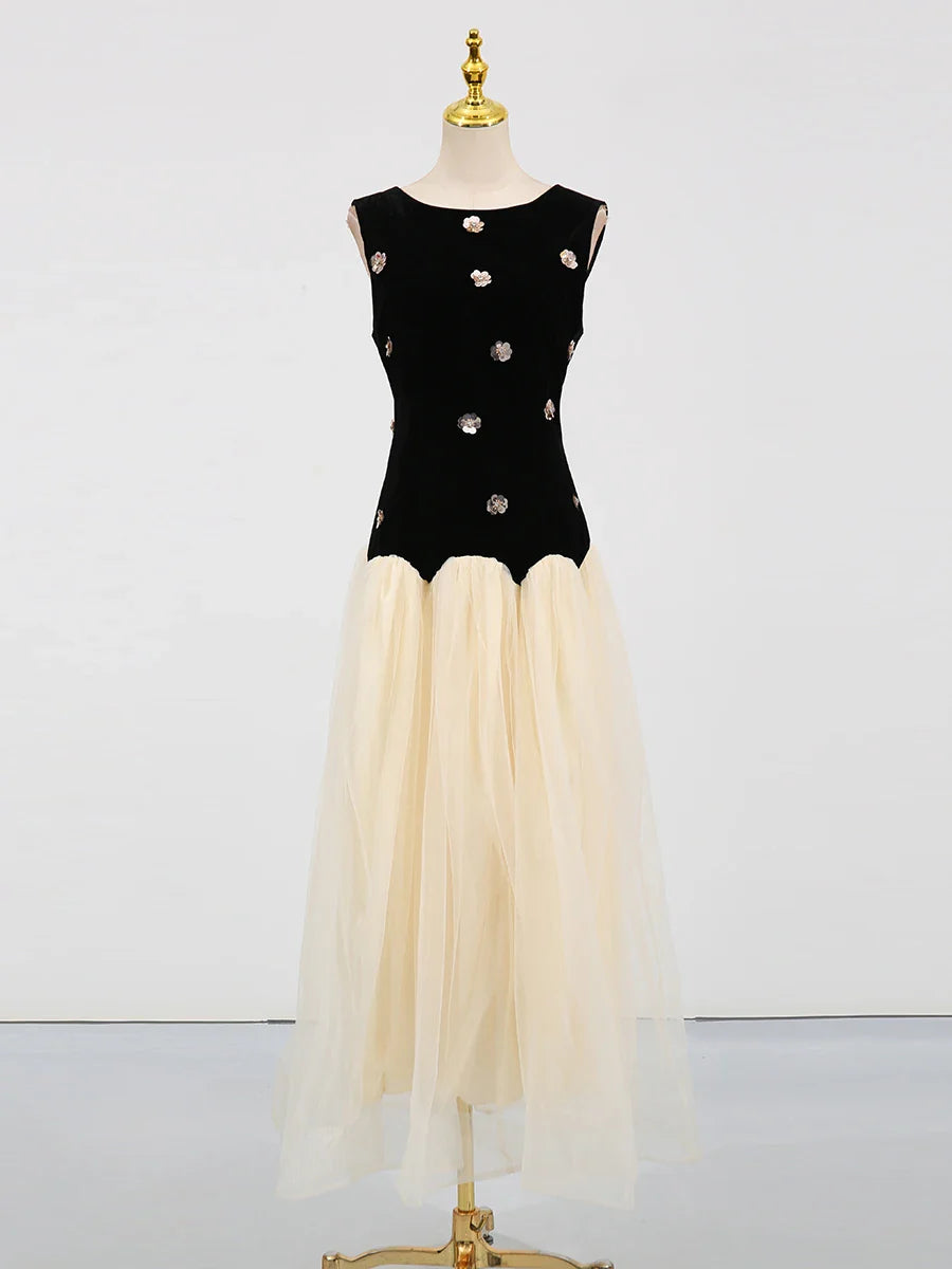 Black top with silver buttons and beige skirt on a mannequin against a white background