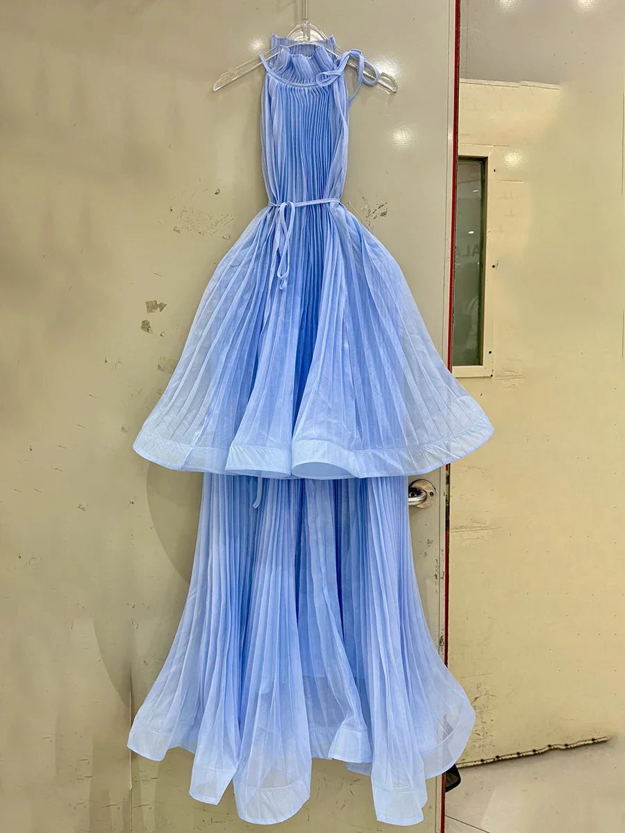 Light blue dress hanging on a hanger against a beige wall.