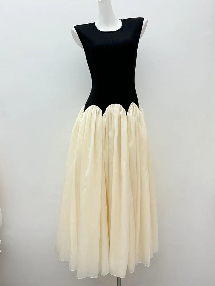Mannequin wearing a black top and cream skirt against a white background